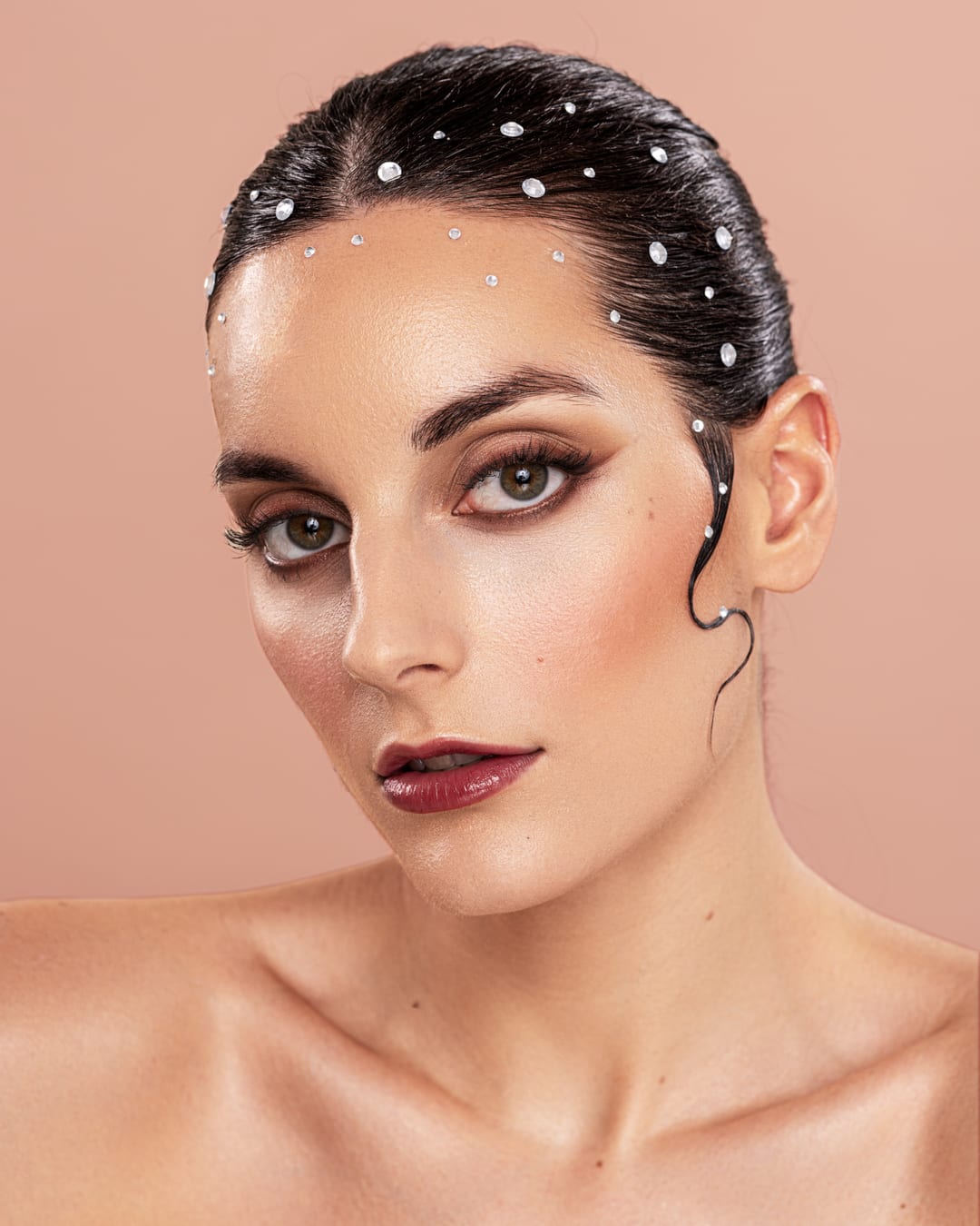 Beauty-Porträt eines Models mit Wet-Look-Frisur und Perlen im Haar